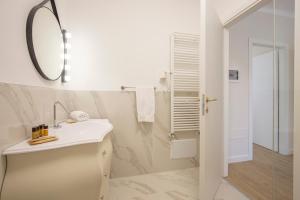 Un baño blanco con lavabo y espejo. en CRYS: Apartments, Holiday, Business, Blu, en Verona 21 fotos más