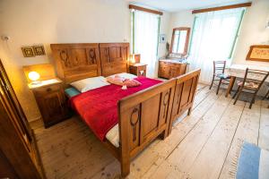 sypialnia z dużym drewnianym łóżkiem i czerwonym kocem w obiekcie Vintage House Podliparska w mieście Fara