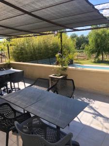 a patio with a table and chairs under an umbrella at Les Centaurines in Saint-Siffret