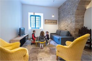 two children are sitting in a living room at LE CANDEZE in Monestiès