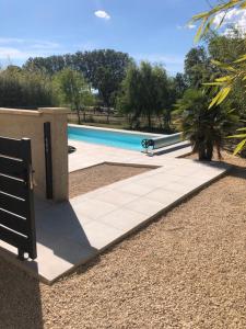 a swimming pool in front of a house at Les Centaurines in Saint-Siffret