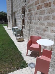 a red chair sitting in front of a brick building at Hotel Delle Cave in Favignana