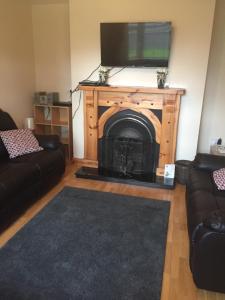 a living room with a fireplace with a tv on top at 39 woodview in Listowel