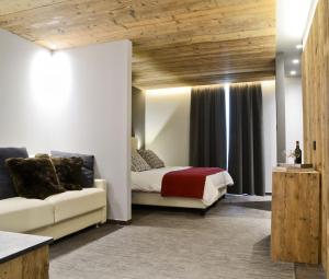 a bedroom with a bed and a couch in a room at Hotel san Vitale in Bormio