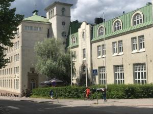 un grand bâtiment avec une tour d'horloge en face dans l'établissement Opiston Kunkku, à Lahti