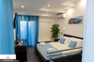 a bedroom with a bed with blue drapes at B&B Marranzanu in Santa Teresa di Riva