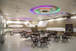 a restaurant with tables and chairs and a colorful ceiling at Shivam Palace & Resort in Jodhpur