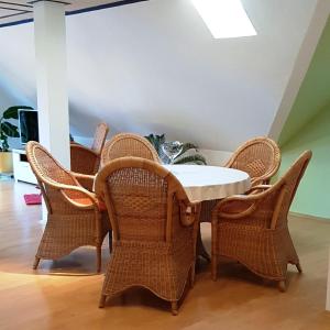 a dining room with a table and wicker chairs at Ferienwohnung In Bestform in Merkendorf