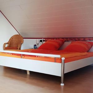 Bett mit roten Kissen auf einem Zimmer in der Unterkunft Ferienwohnung In Bestform in Merkendorf