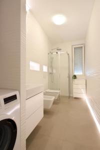 een witte badkamer met douche en toilet bij Modern apartment near the sea in Ičići