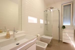 een witte badkamer met een wastafel en een douche bij Modern apartment near the sea in Ičići +7 foto's