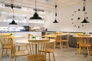 a restaurant with tables and chairs and a clock on the wall at Hotell Vilja in Umeå