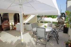 a table and chairs under an umbrella on a patio at Villa Lavanda in Pag
