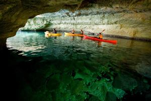 a group of people in kayaks in a cave at ARTIEM Audax - Adults Only in Cala Galdana