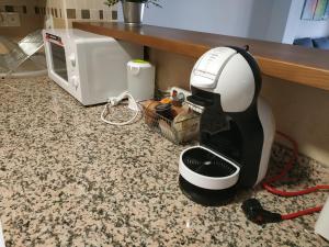 a coffee maker sitting on a counter next to a microwave at La Magacén. in Mora de Rubielos