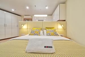 モスクワにあるNakvartire Apartments in YE'Sのベッドルーム1室(大型ベッド1台、黄色と青の枕付)