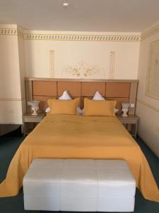 a bedroom with a large bed with a yellow bedspread at Hotel Ristorante La Terrazza in Planegg