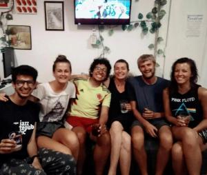 un grupo de personas sentadas en un sofá con bebidas en Hostel El Diablo, en Belgrado