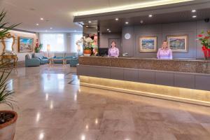 a lobby with two women standing at a counter at 4R Playa Park in Salou