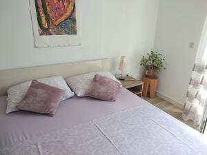 a bedroom with a bed with two pillows on it at Apartments Luka in Lumbarda
