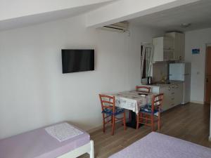 a room with a table and chairs and a kitchen at Apartments Luka in Lumbarda +19 photos
