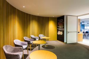 a waiting room with yellow walls and chairs and tables at ARTIEM Audax - Adults Only in Cala Galdana