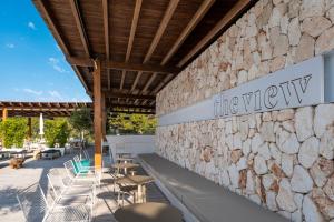 a restaurant with a stone wall and tables and chairs at ARTIEM Audax - Adults Only in Cala Galdana