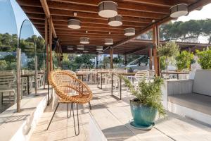 a patio with chairs and tables on a building at ARTIEM Audax - Adults Only in Cala Galdana