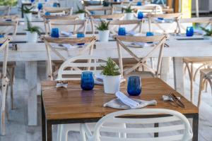 a wooden table with chairs and blue glasses on it at ARTIEM Audax - Adults Only in Cala Galdana