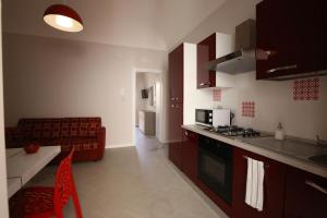 eine Küche und ein Wohnzimmer mit einem Sofa in der Unterkunft Sole d'Ortigia in Syrakus