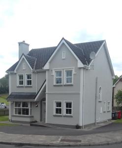 uma casa branca com um telhado cinzento em Farmleigh House, em Donegal