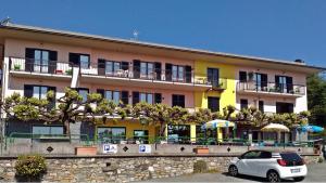 a building with a car parked in front of it at Hotel La Capannina in Massino Visconti