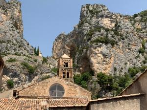 a church in front of a rocky mountain at Appartement l’étoile in Moustiers-Sainte-Marie