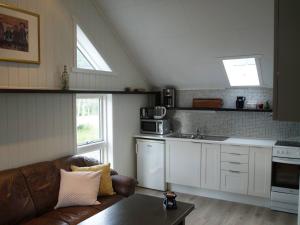 a living room with a couch and a kitchen at Siloen - cosy apartment in Herand in Herand