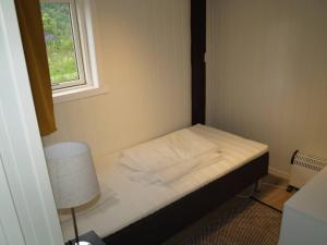 a small bed in a small room with a window at Siloen - cosy apartment in Herand in Herand