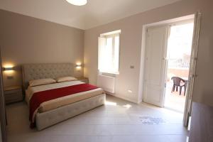 ein Schlafzimmer mit einem Bett und einem großen Fenster in der Unterkunft Sole d'Ortigia in Syrakus
