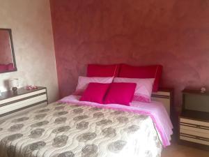 una camera da letto con un grande letto con cuscini rosa di A due passi a Pietrapertosa