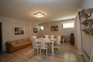 salon ze stołem, krzesłami i kanapą w obiekcie Villa Farran 1 w mieście Loukísia
