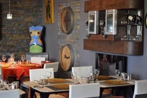 a restaurant with tables and chairs and a fireplace at Logis H&ocirc;tel La Fauceille in Perpignan