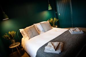 a bedroom with a large white bed with towels on it at The Barbershop Apartments in Manchester