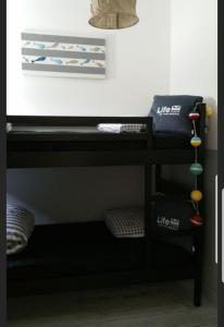 a black bunk bed with two pillows on it at Maison carnac plage in Carnac