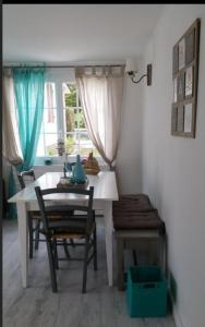 a dining room with a table and chairs and a window at Maison carnac plage in Carnac