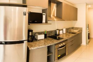 W kuchni znajduje się lodówka ze stali nierdzewnej i kuchenka mikrofalowa. w obiekcie Realty PY Villa Morra w mieście Asunción