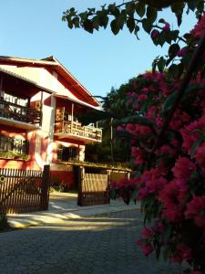 a building with pink flowers in front of it at Vila de Sol in Bombinhas