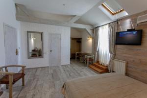 a bedroom with a bed and a television on a wall at Zdybanka in Sumy