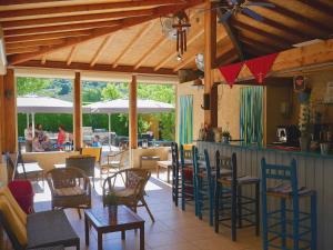 a restaurant with a bar with chairs and tables at Les Cigalous in Salavas