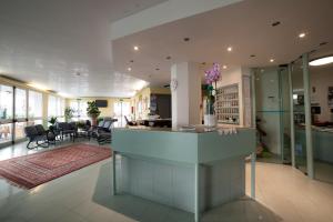 a lobby with a reception counter and a dining room at Hotel Plaza in Rimini