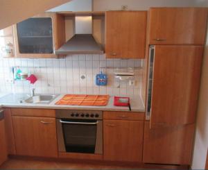 a kitchen with wooden cabinets and a stove top oven at Ferienwohnung Steible in Isny im Allgäu