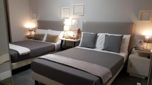 a hotel room with two beds and two lamps at Musica Guest House in Alghero