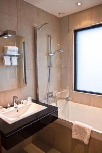 a bathroom with a sink and a shower and a tub at Villa Azur in Villeneuve-Loubet